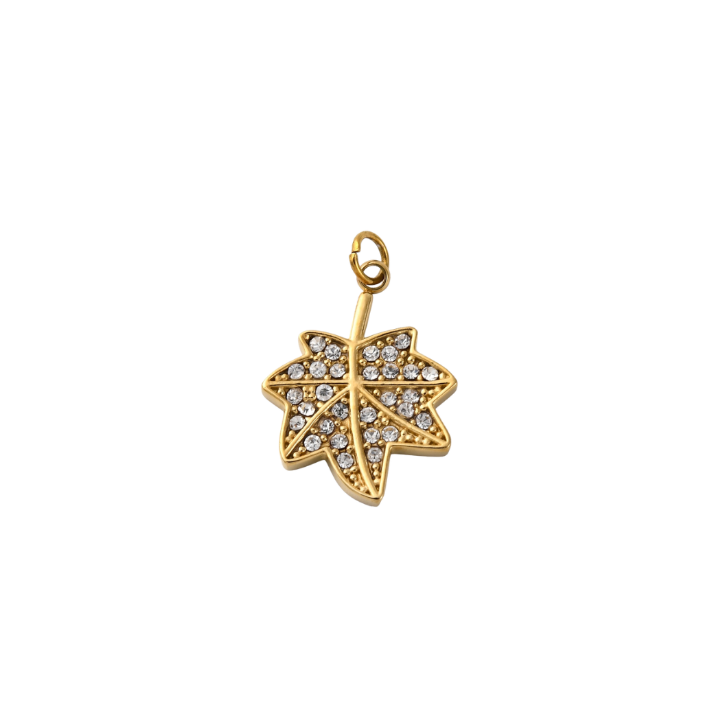 Gold leaf-shaped pendant with embedded crystals on a white background