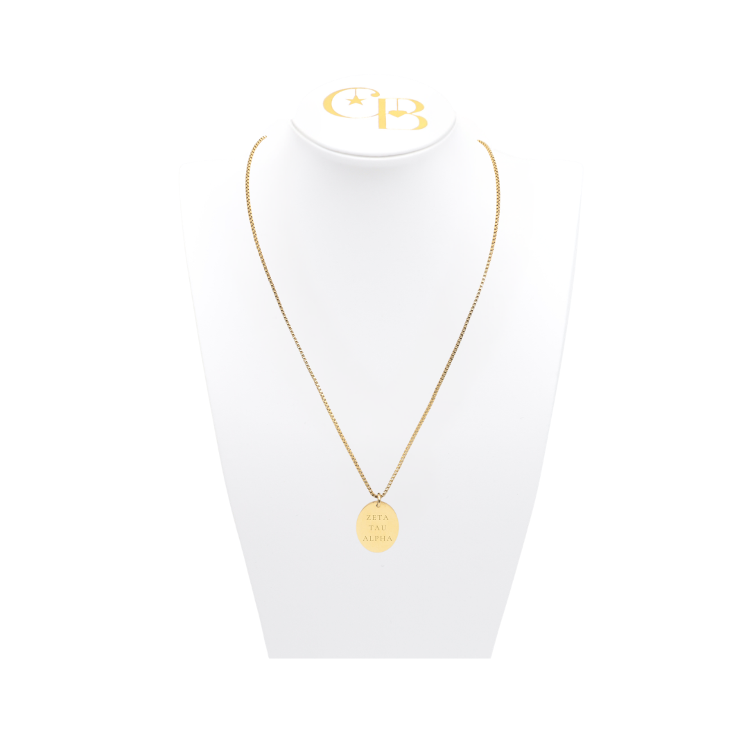 Zeta Tau Alpha gold box chain necklace with large oval charm displayed on which necklace bust front view with full sorority name
