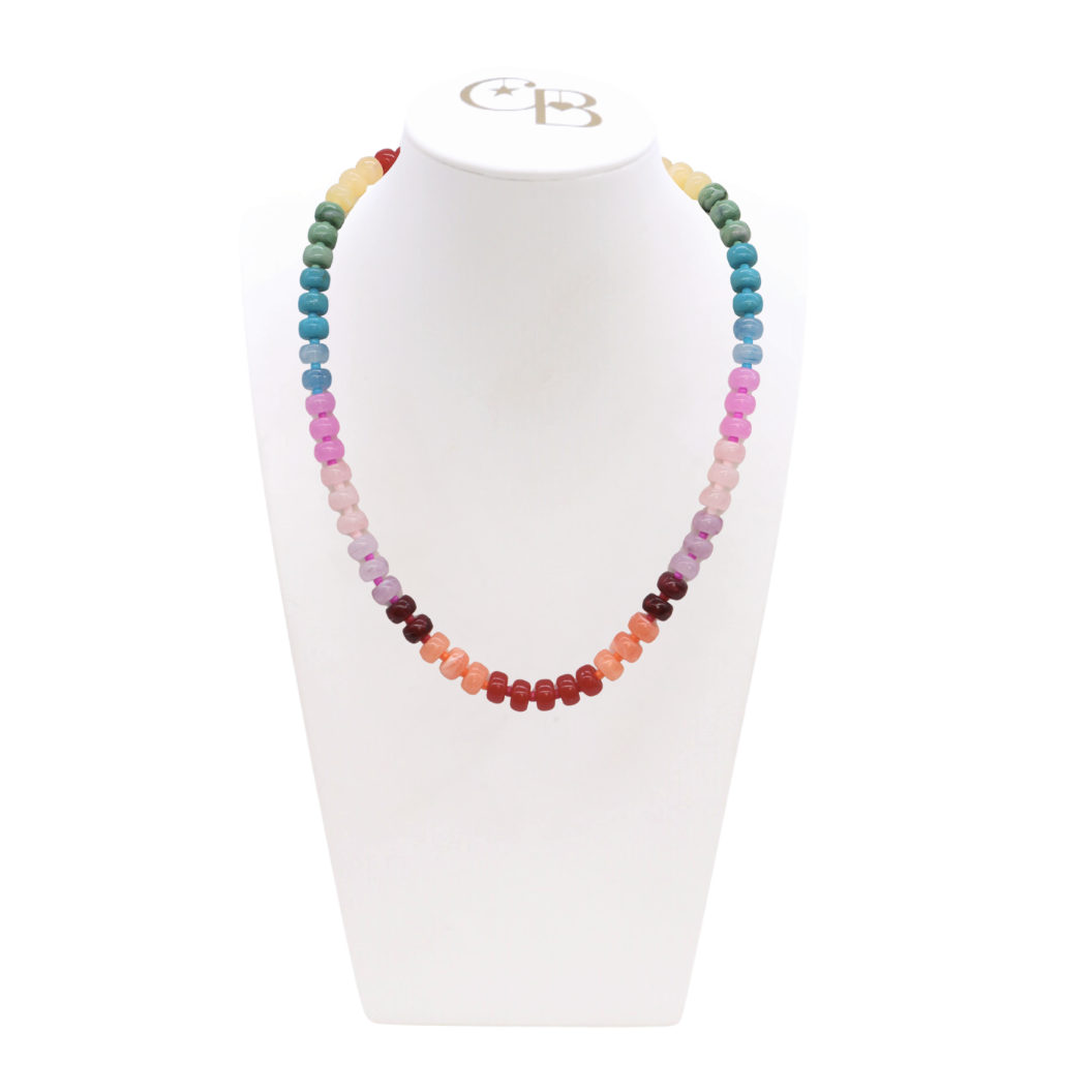 Multicolored beaded necklace on a white stand with a visible brand logo.