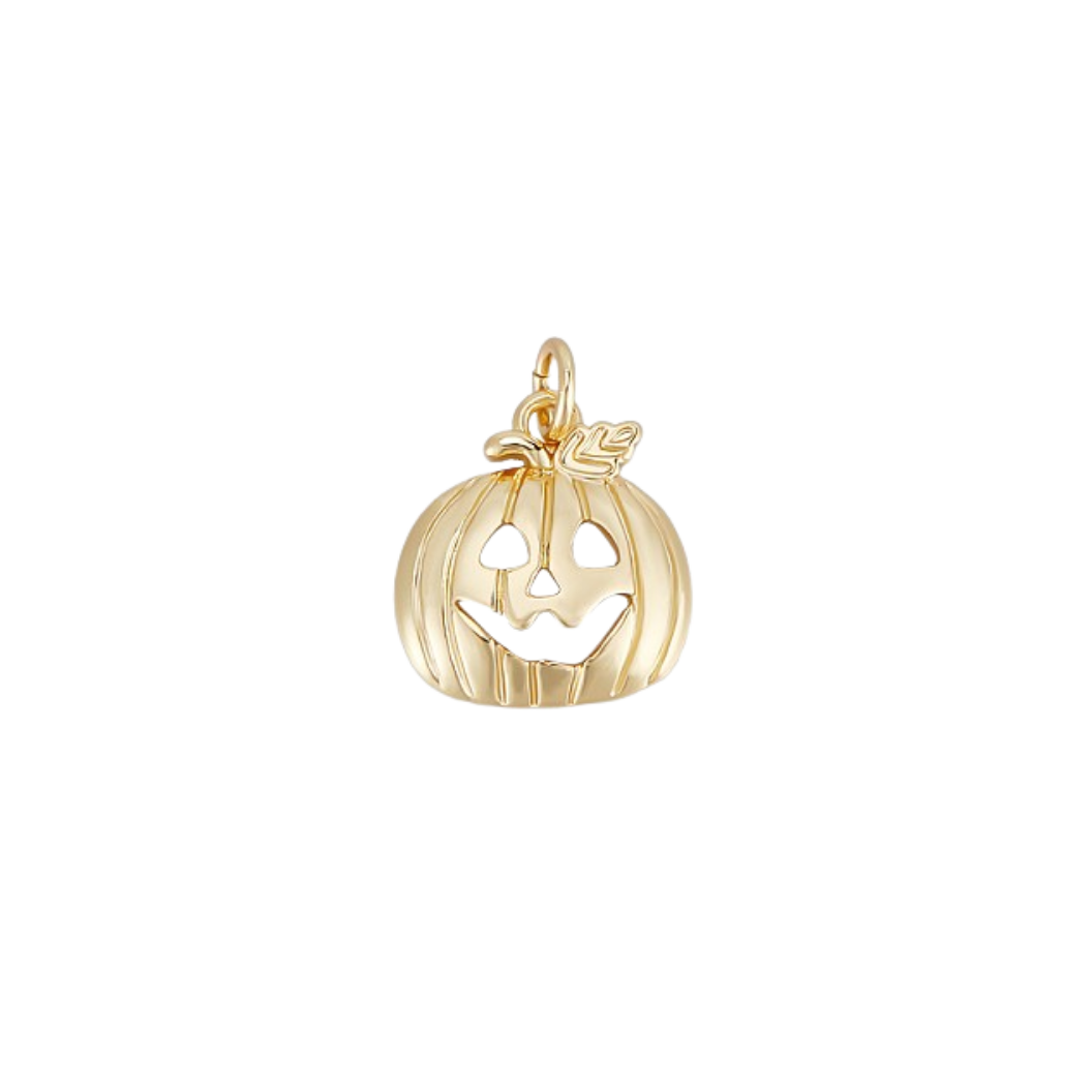 Gold pumpkin charm with a face on a white background