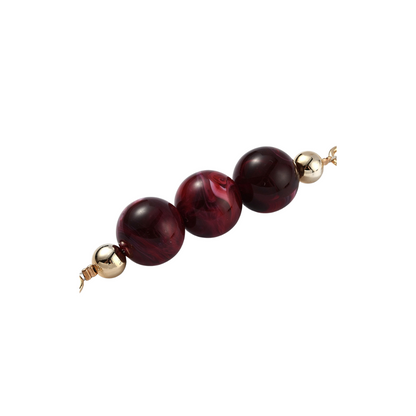 Beaded necklace with red beads and gold clasps on a white background