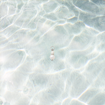 Pearl earring on a textured light blue surface