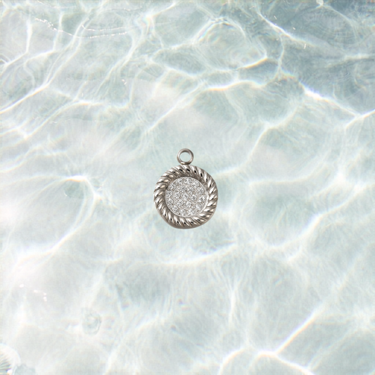 Silver cross pendant on a textured white background