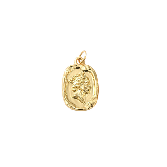 Gold pendant with a face design on a white background