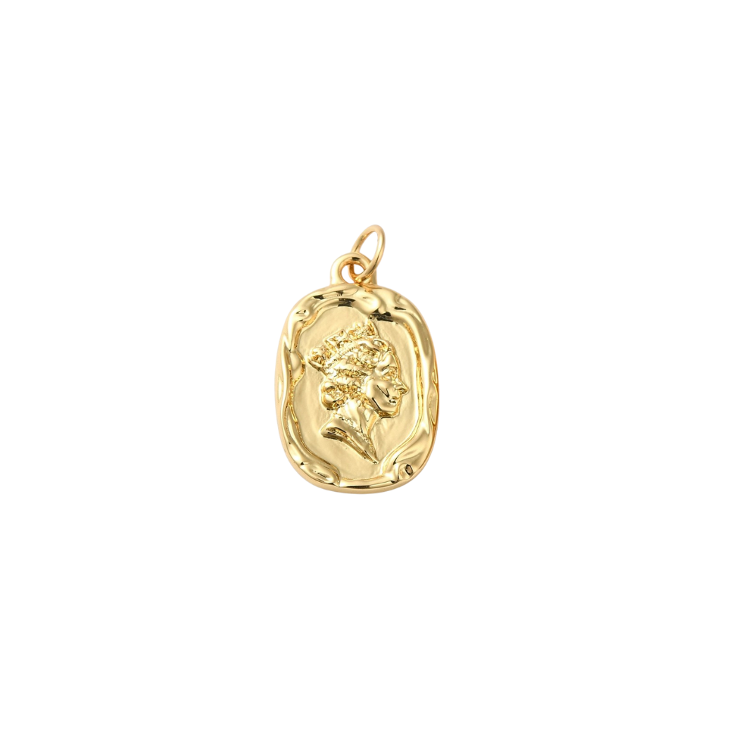 Gold pendant with a face design on a white background