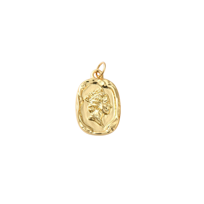Gold pendant with a face design on a white background