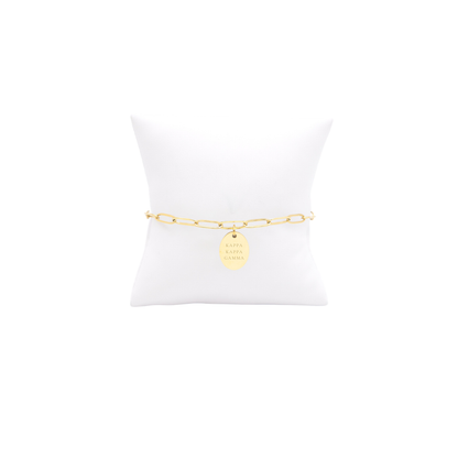 Kappa Kappa Gamma gold link storyline bracelet with small oval charm with full sorority name on white pillow front view
