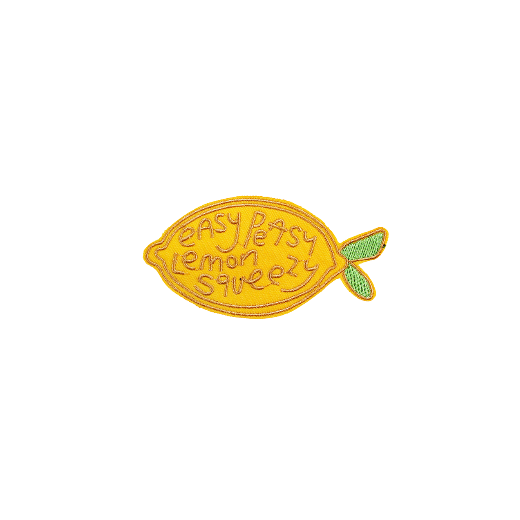 Yellow lemon-shaped patch with 'easy peasy lemon squeezy' text on a white background