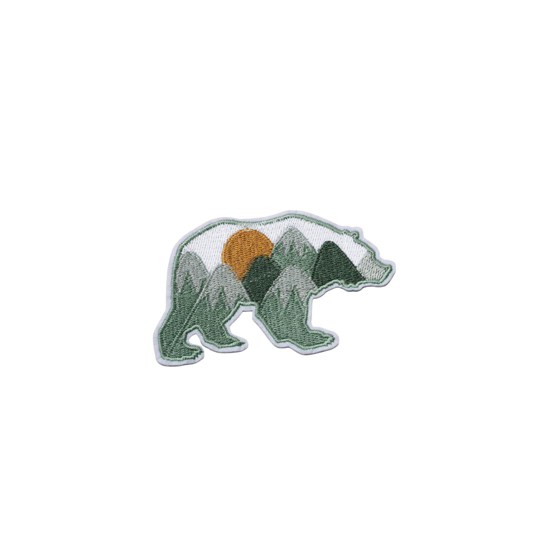 Embroidered patch of a bear with mountain design on a white background