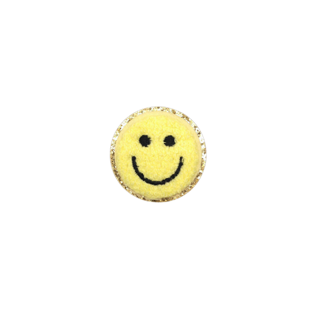 Round yellow object with a smiley face design on a white background