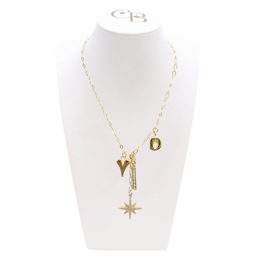 Gold necklace with charms on a white mannequin bust