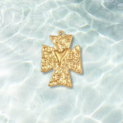 Gold cross pendant on a textured white background