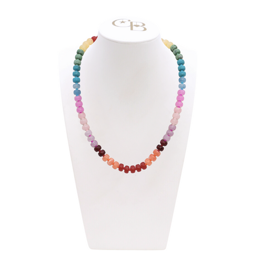 Multicolored beaded necklace on a white stand with a visible brand logo.