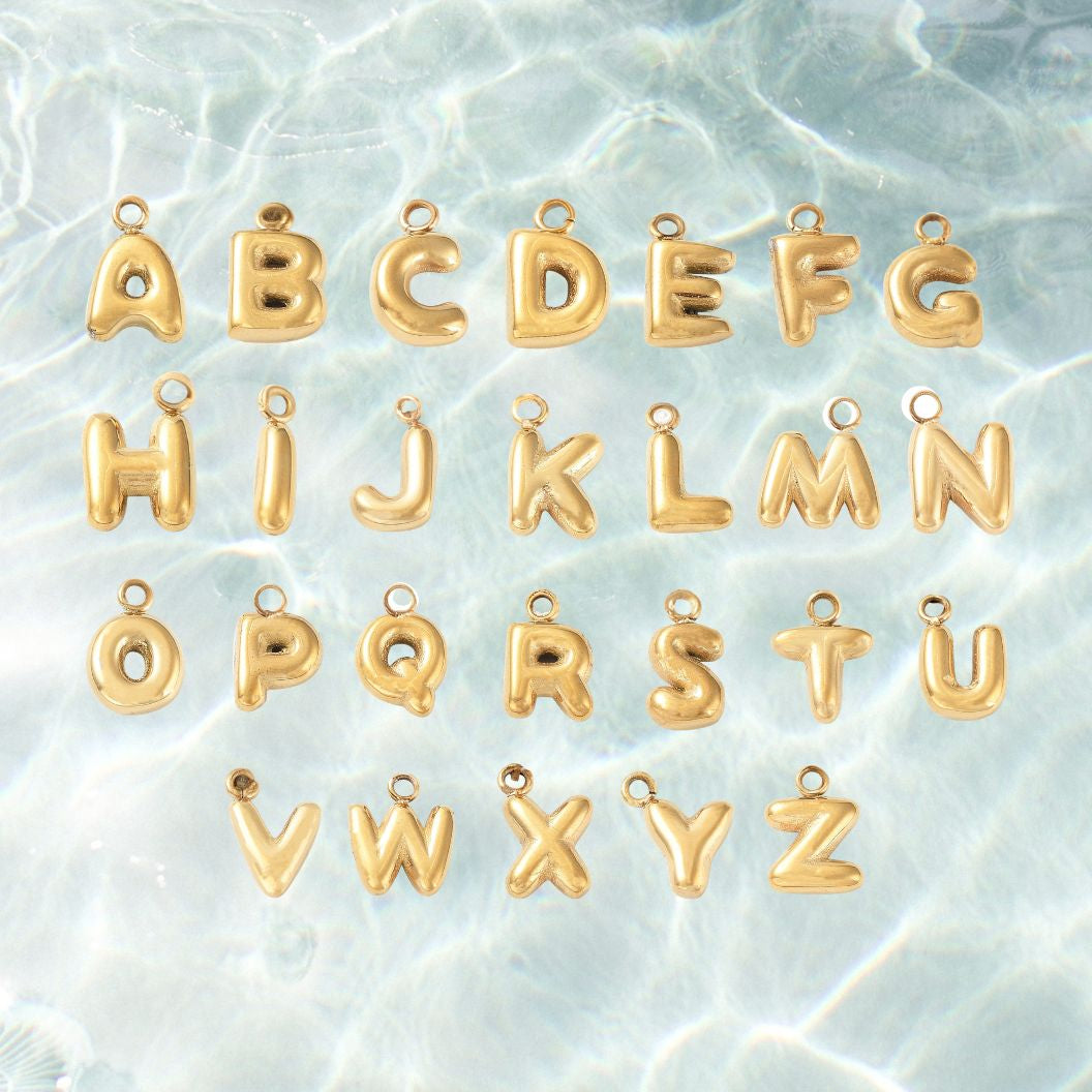 Gold letter charms on a textured light blue background