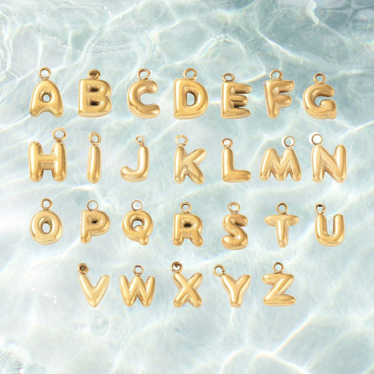 Gold letter charms on a textured light blue background
