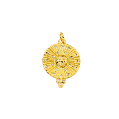 Gold pendant with sun design on a white background