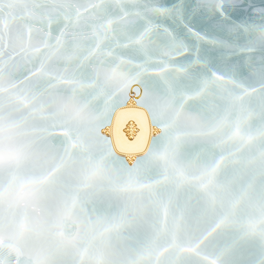 Gold Regal Crest Charm | Waterproof Stainless Steel on water background 