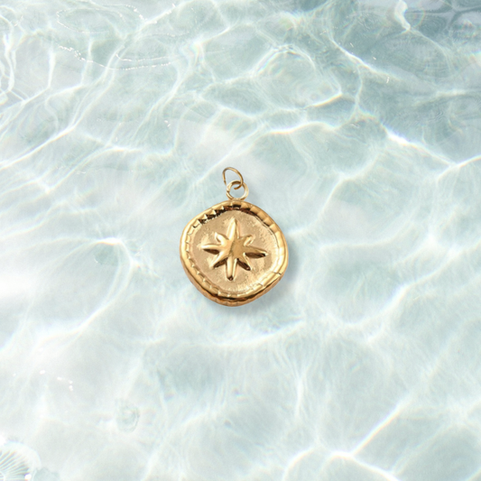 Gold Guiding Star Medallion Charm | Waterproof Stainless Steel on water background