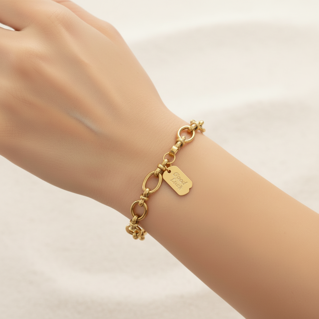 Gold Good Luck Dog Tag Charm attached to bracelet on woman's arm 