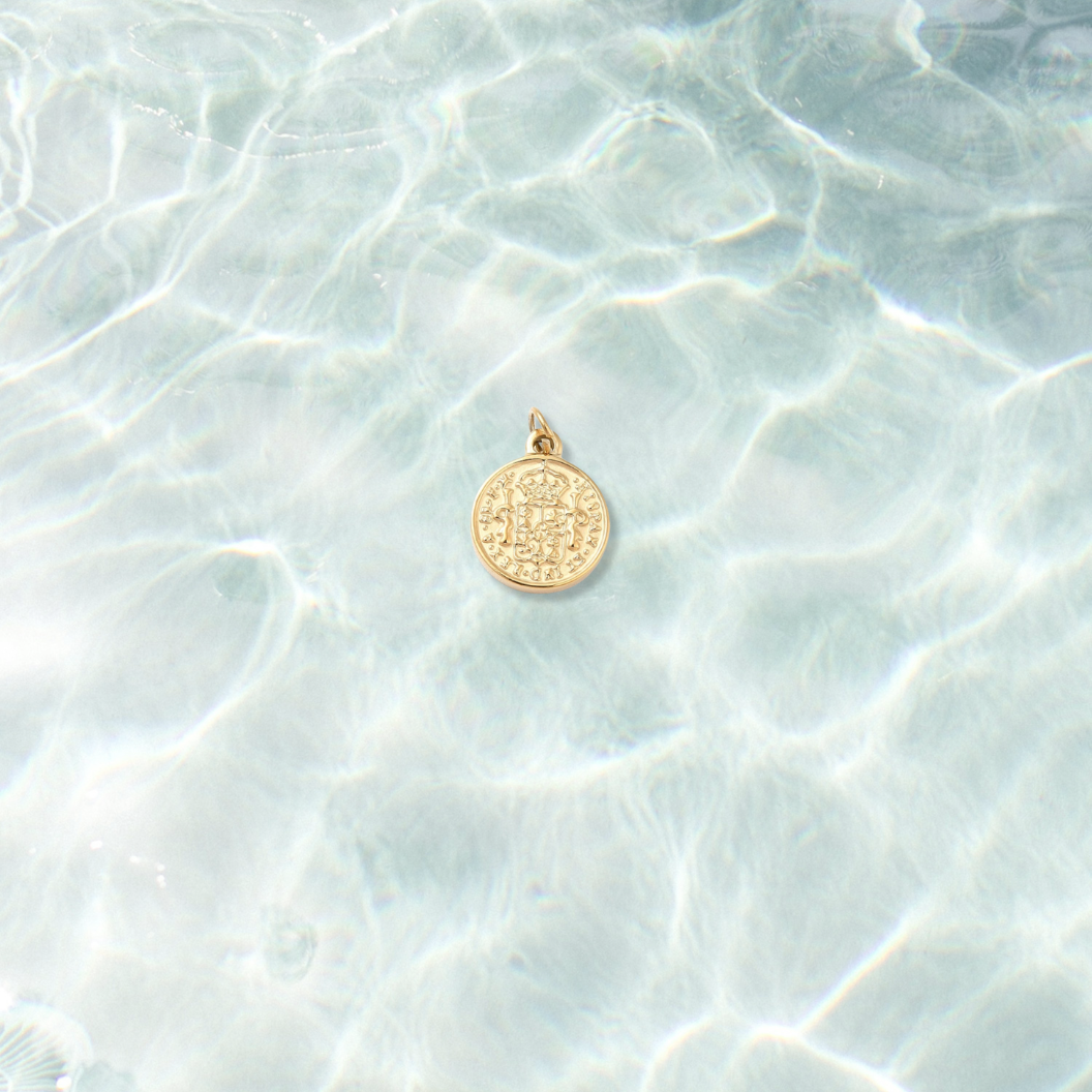 Gold Imperial Vintage Coin Charm on water background 