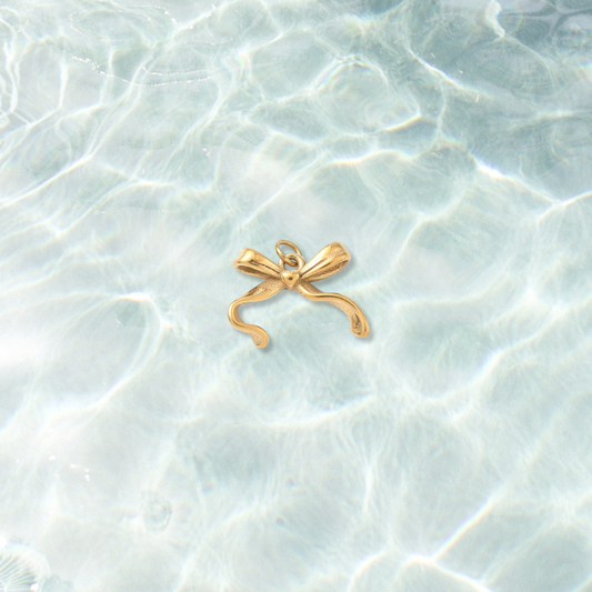 Gold Lovely Ribbon Bow Charm  on water background 