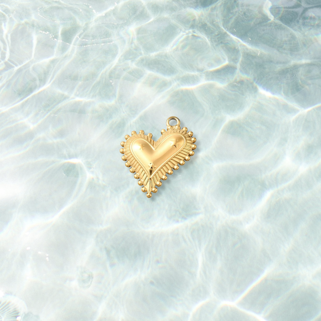 Gold Trinity Heart Burst Charm  on water background