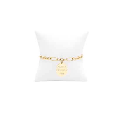 Alpha Epsilon Phi gold large link keepsake bracelet with large oval charm with horizontal greek letters on white pillow front view