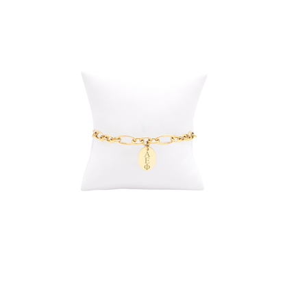 Alpha Epsilon Phi gold large link keepsake bracelet with small oval charm displayed on white pillow front view with horizontal greek letters