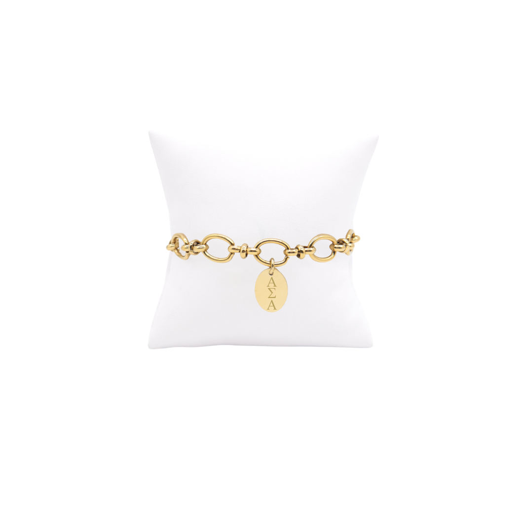 Alpha Sigma Alpha gold large link evermore bracelet with small oval charm displayed on white pillow front view with vertical/stacked greek letters