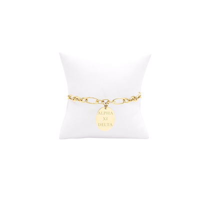 Alpha XI Delta gold large link keepsake bracelet with large oval charm displayed on white pillow front view with full sorority name