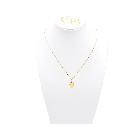 Chi Omega gold link storyline necklace with small oval charm with horizontal greek letters on white bust front view
