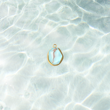 Gold aqua gemstone charm on a waterproof background