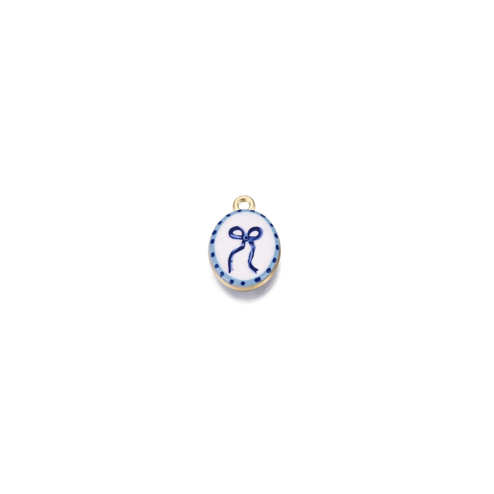 Gold Blue Bow Charm featuring a delicate navy blue bow illustration on a white oval enamel background with a dotted blue border. 
