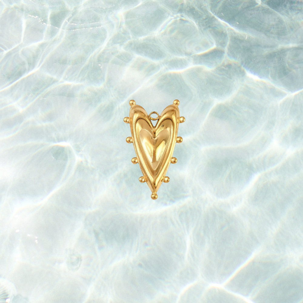 Gold bold heart charm on waterproof background