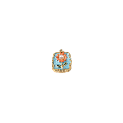 Gold square floral tile charm with pearl tile charm with blue enamel background, orange flower details and pearl center on a white background