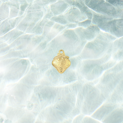 Gold fresh picked strawberry charm with a polished finish, embossed seed details and leafy top design on a waterproof background