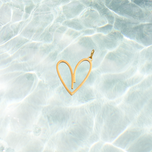 Gold open heart charm featuring a minimalist open heart design on a shimmering water background.