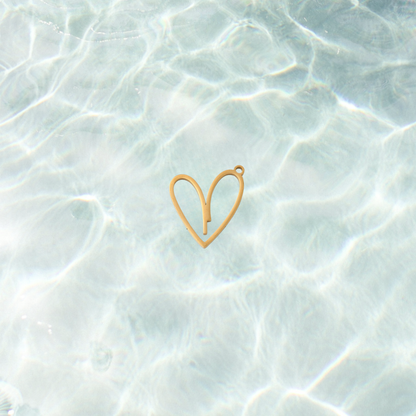 Gold open heart charm with minimalist outline design on a waterproof background