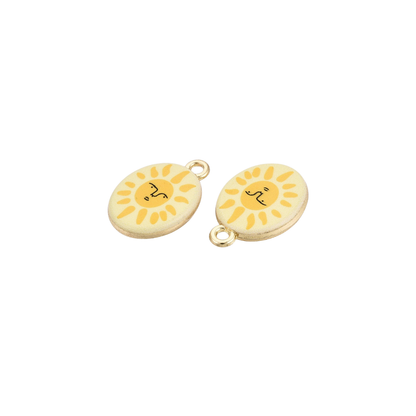 Two gold oval charms featuring smiling sun face illustrations with yellow rays on a cream background