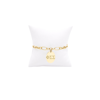 Phi Sigma Sigma gold large link keepsake bracelet with large oval charm displayed on white pillow front view with horizontal greek letters