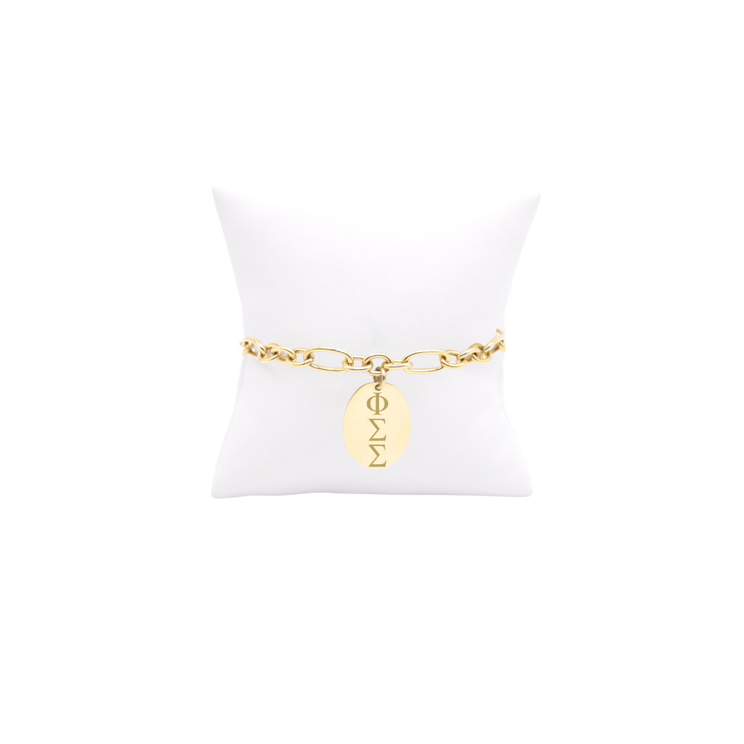 Phi Sigma Sigma gold large link keepsake bracelet with large oval charm displayed on white pillow front view with vertical/stacked greek letters