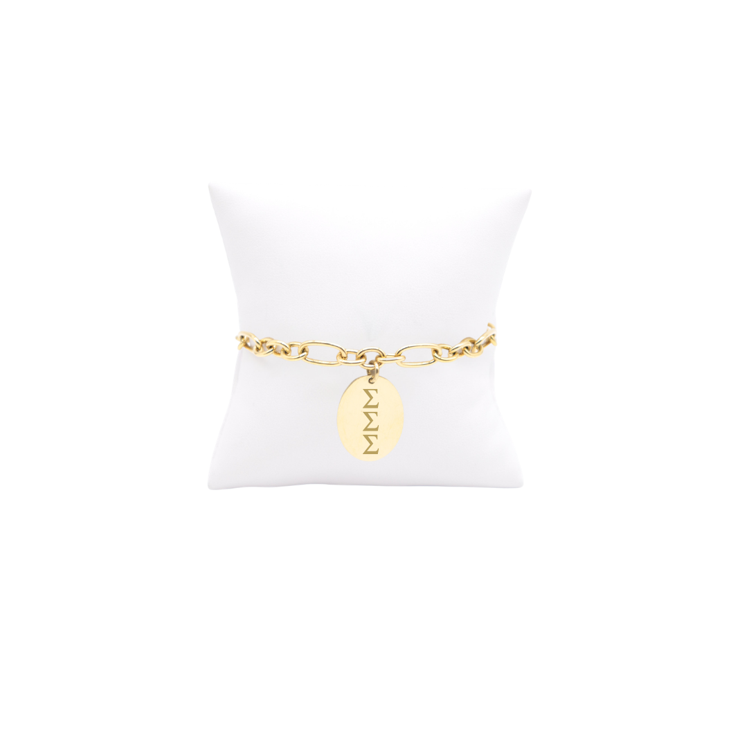 Sigma Sigma Sigma gold large link Keepsake bracelet with large oval charm with vertical greek letters on white pillow front view
