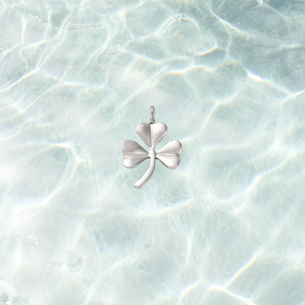 Silver shamrock charm on a waterproof background.