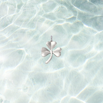 Silver shamrock charm on a waterproof background.