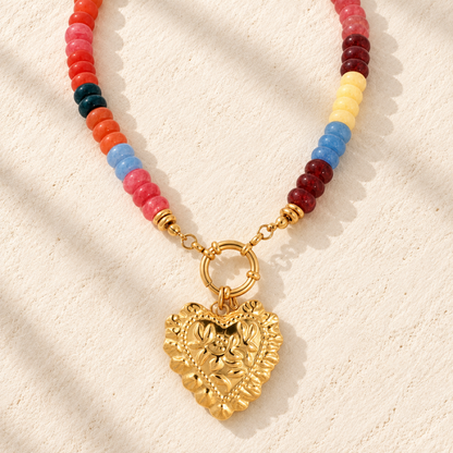 Armor Heirloom Beaded Necklace with multicolor red, pink, orange, yellow, blue and deep teal beads, finished with gold-tone hardware and an ornate heart pendant.