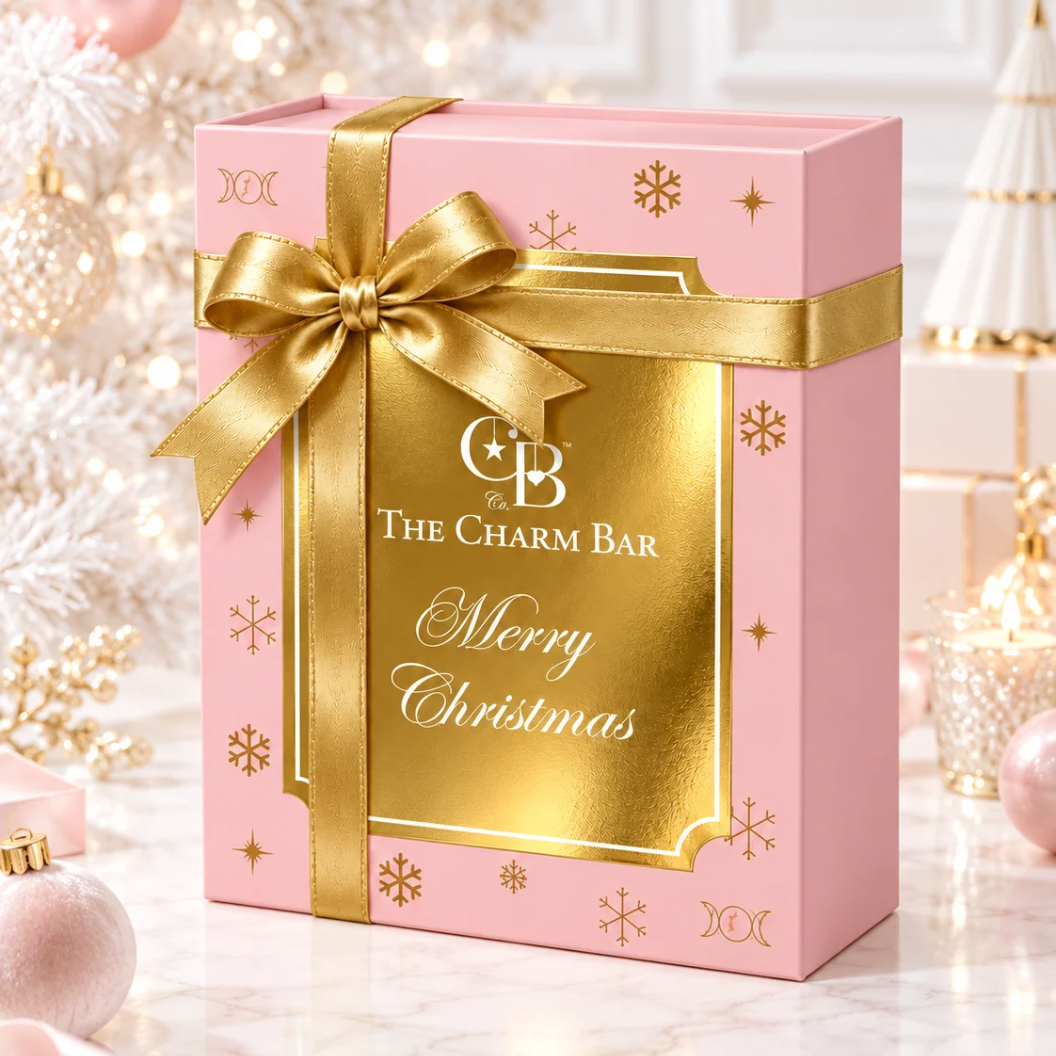 The Charm Bar Company limited edition Heirloom Advent Calendar in an elegant pink and gold Christmas gift box with gold ribbon and festive holiday decorations.