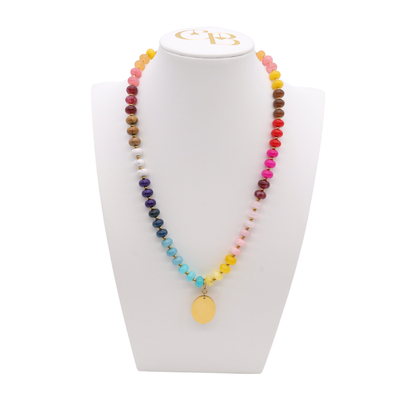 Desert Heirloom Beaded Necklace featuring turquoise, navy, pink, red, yellow, and cream beads with gold-tone accents and a smooth oval pendant.