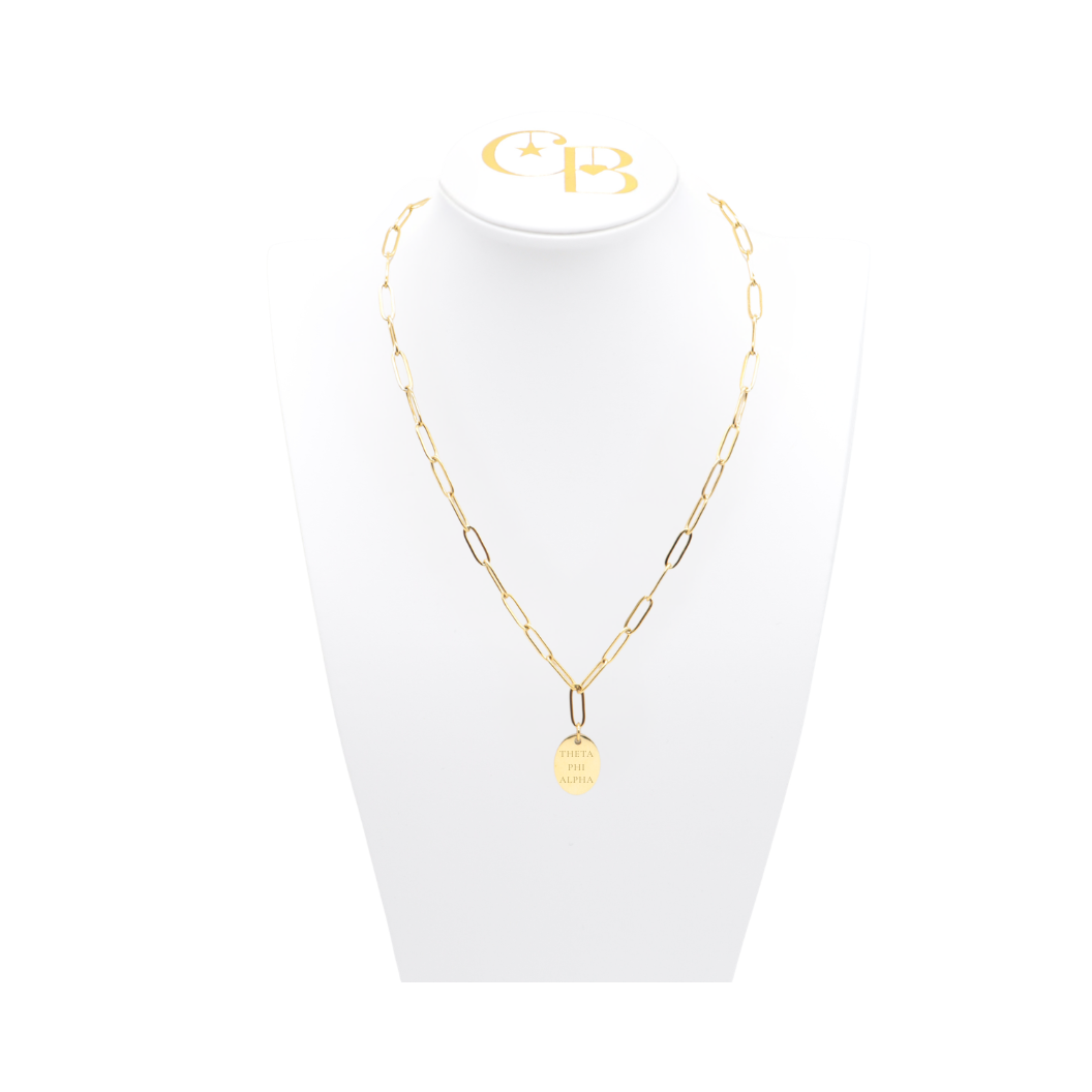 Theta Phi Alpha gold link storyline necklace with small oval charm displayed on white necklace bust front view with full sorority name